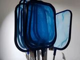 un vase bleu dans lequel se trouve un ensemble d'ustensiles