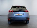 the rear end of a silver car in a white room