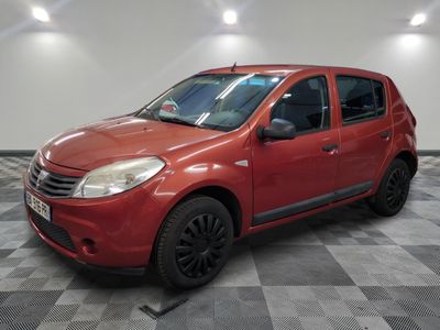 la petite voiture rouge est garée dans le garage sur un sol en damier
