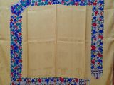 une image représentant une nappe jaune ornée de fleurs bleues et rouges