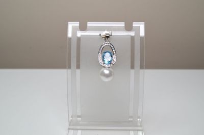 une petite vitrine contenant une pierre bleue et un pendentif en perle