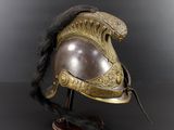 an antique helmet on a wooden stand with a black background