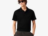 un homme vêtu d'un polo noir et d'un pantalon gris