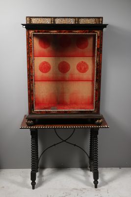 an old wooden cabinet with a red and gold design on it