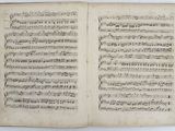 an open book with music notes on it sitting on a table