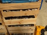 une caisse bleue remplie de pierres, posée sur une palette