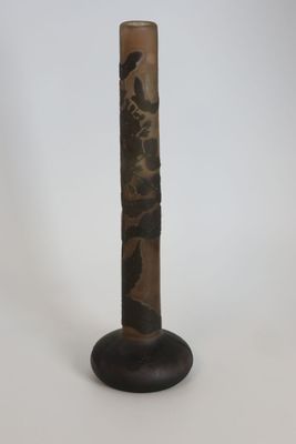 a tall vase with a bird on top of it