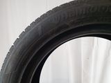 a close up of a tire on a white surface with a white curtain in the background