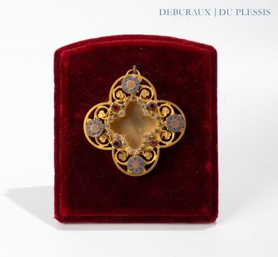 une image représentant une broche en or posée sur un écrin en velours rouge