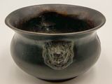 a black bowl with a lion head on it