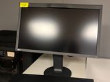 un écran d'ordinateur posé sur un bureau blanc