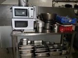 une cuisine où de nombreuses casseroles et poêles sont posées sur le plan de travail