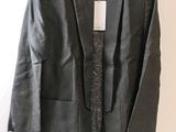 black blazer jacket with lace trimmings on a hanger on a white wall