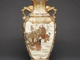 a vase with a painting on it sitting on a table
