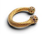 a close up of a gold bracelet with multi colored stones