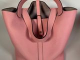 a pink handbag with a handle on a white background