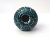 a blue and green vase sitting on a white surface