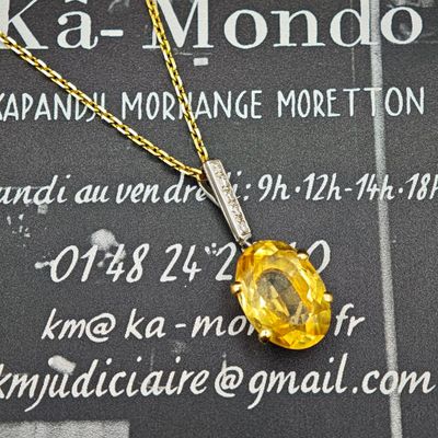 un collier jaune orné d'un diamant, posé sur une table