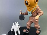 statue représentant un homme en combinaison de plongée avec un chien posé sur une table