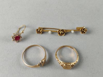 three gold rings and a pair of earrings are sitting on a table