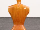 a wooden mannequin sitting on a gray surface
