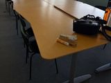 une longue table sur laquelle se trouve un sac, dans une pièce