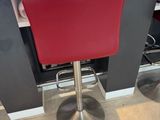 two red stools sitting in front of a counter