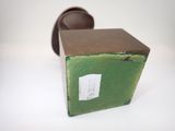 a small green box with a brown lid on a white surface