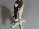 a figurine of a bird that is sitting on a branch