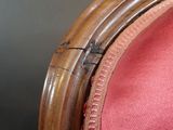 a close up of a red chair with a crack in the back