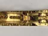 a close up of a gold bracelet on a white surface