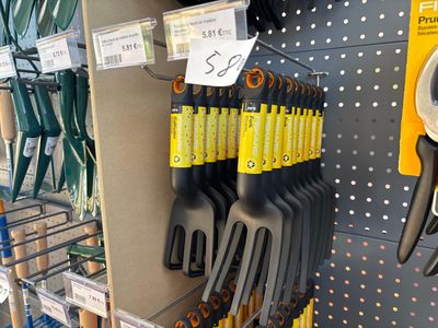 a rack of gardening tools in a store for sale
