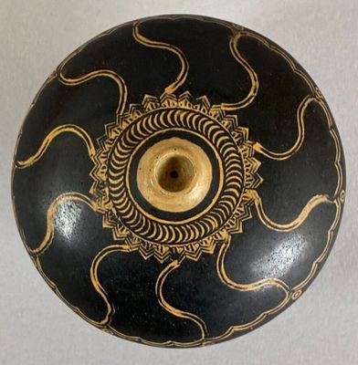 a black and gold vase with a gold design on it