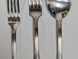 four forks and a spoon sitting on a table