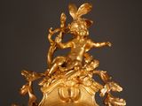 a gold clock with a statue on top of it