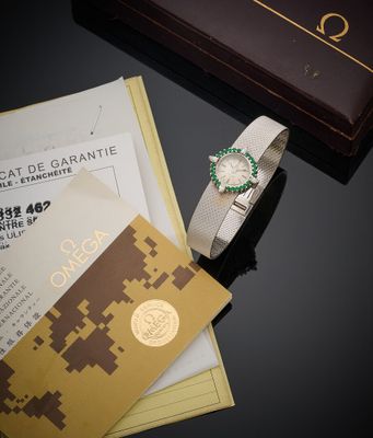 une montre posée sur une table, à côté d'une feuille de papier