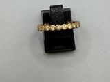 gros plan d'une bague en or avec des diamants sur une surface blanche