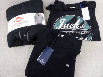 une chemise noire et un pantalon noir posés sur un lit