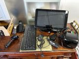 a desk with a laptop, keyboard, mouse, and other electronics on it