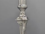 an antique silver plated candle holder with a candle on top of it