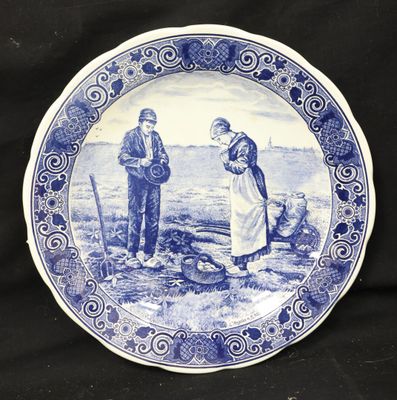 a blue and white plate with a picture of a man and a woman