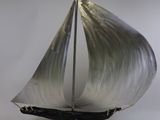 une maquette en métal d'un voilier posée sur un socle