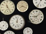 many different types of clocks displayed on a black surface