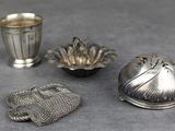 trois objets en argent posés les uns à côté des autres sur une table