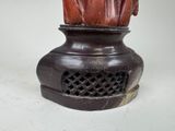 a statue of a man with a hat on top of a vase