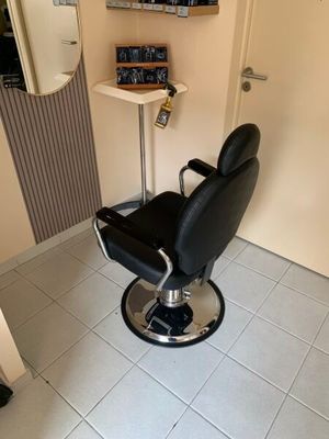 un fauteuil de coiffeur noir dans un coin de la pièce