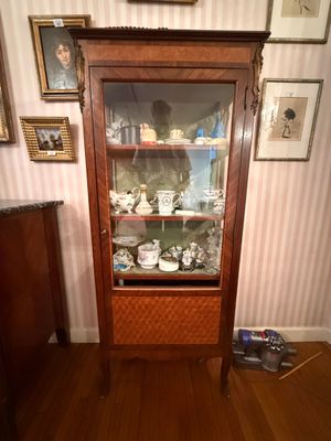 une armoire avec une porte vitrée au milieu d'une pièce