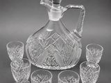 a clear glass decanter with six glasses and a decanter