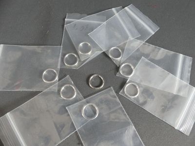 six clear bags with rings on them on a table