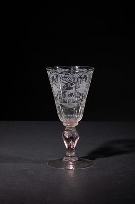 a wine glass sitting on a table with a black background